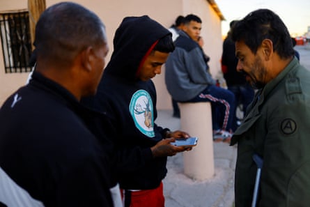 Migrants seeking asylum in the US use their phones to request an appointment through the CBP One application.