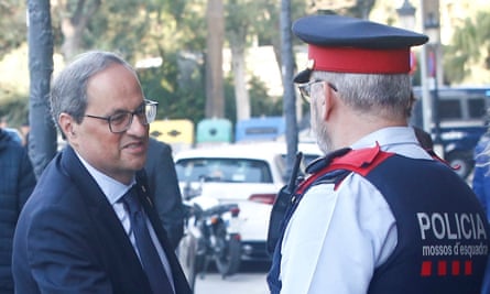 Quim Torra is welcomed by a policeman upon his arrival in Barcelona.
