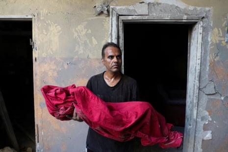 Shadi Mansour carries the body of his son Ameer, who was killed in an Israeli strike on a house in Gaza City.