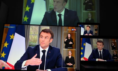 French President Emmanuel Macron is seen on screens in the French city of in Mulhouse during his TV interview.