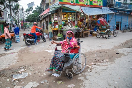 A woman in wheelchair begs in the street