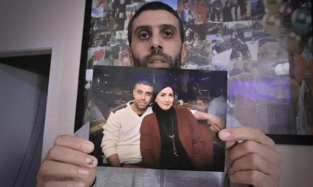 Muhamad Abu Muammar, 35, holds a picture of his wife Sharifa Abu Muammar, 30, who was killed by a stray bullet while preparing a bottle of milk for her baby, in her kitchen.