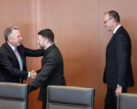 Steve Witkoff and Volodymyr Zelenskyy shake hands as Germany’s chancellor looks on