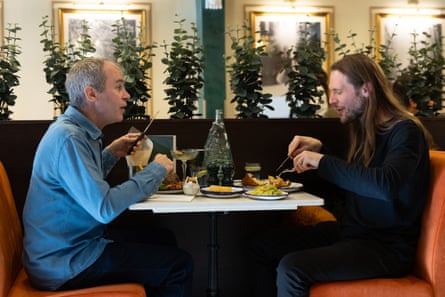 Philip and Carl chatting and eating at a restaurant table