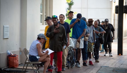 Homeless and low-income people queue to register for free food outside a church in downtown Tampa, Florida