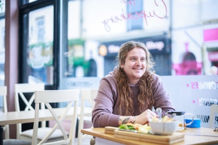 Freeman sat at table with street visible behind through window