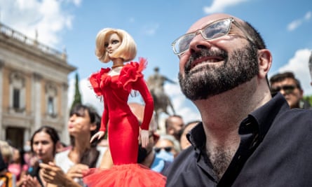 A man holds a doll of Raffaella Carrà