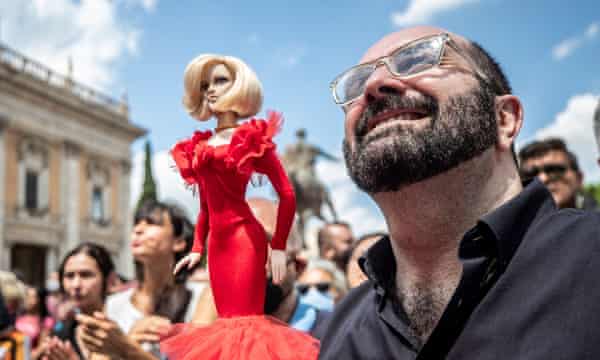 A man holding a doll of Raffaella Carrà