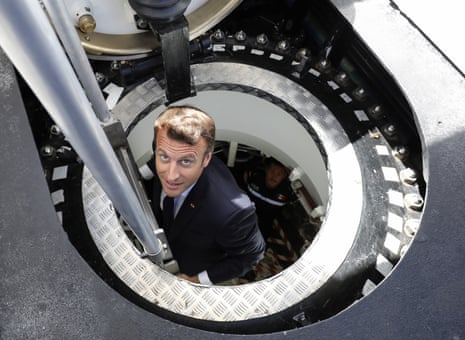 Emmanuel Macron climbs out of a submarine.