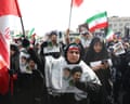 Iranians waving flags and holding pictures of slain leader, Ayatollah Ali Khamenei, and his son and successor