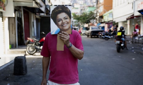 An anti-impeachment protester in Rocinha holds a photograph of President Dilma Rousseff