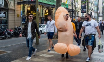 Six men on a stag party with the groom-to-be wearing an inflatable penis costume walk along la Rambla