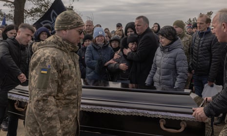 Lidiia (C) mourns over the coffin of her son Serhii Myronchykov, 32, a Ukrainian serviceman from “Da Vinci Wolves” battalion, killed near Bakhmut, during his funeral on March 18, 2023 in Hnidyn village, Kyiv region, Ukraine. Ukraine’s First Mechanized Battalion, known as “Da Vinci Wolves,” were until recently under the command of Dmytro Kotsiubailo, known as “Da Vinci” due to an affinity for art. Kotsiubailo was killed last week in Bakhmut. (Photo by Roman Pilipey/Getty Images)