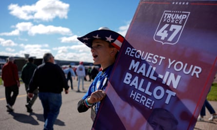 Man wearing American hat holds up sign