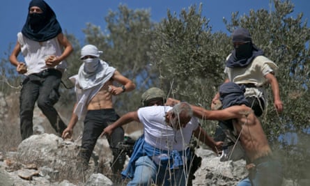 Masked Israeli settlers attack a Palestinian olive farmer