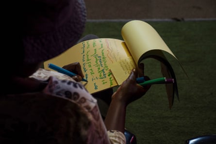 A woman seen from behind writing on a pad of paper