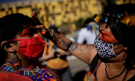 Sônia Guajajara is painted on her face by fellow indigenous leader Alessandra Munduruku during a protest for land demarcation and against President Jair Bolsonaro’s government in Brasília in June.