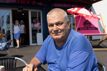 Chris sits at a table outside a cafe