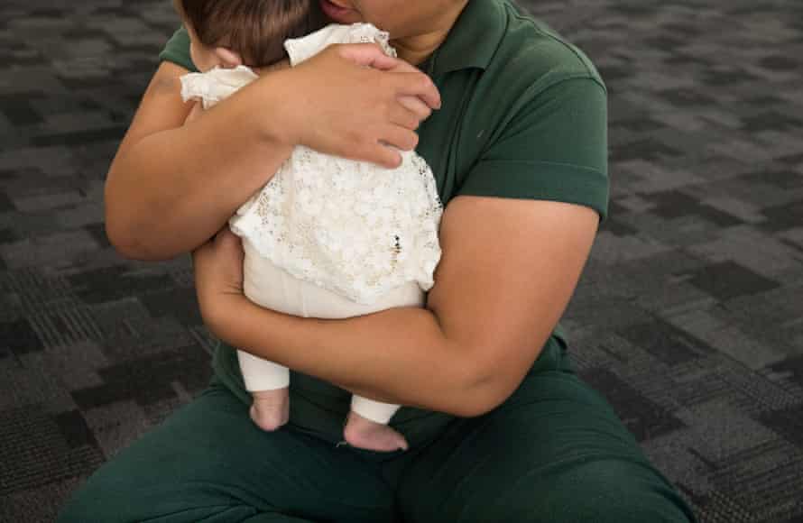 A mother cuddles her three-month-old baby who is at the prison for a rare visit.