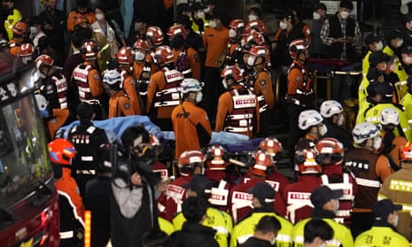 Rescue workers, firefighters and police officers respond to the disaster in Seoul where scores of people died in a crush in a narrow street during Halloween festivities.