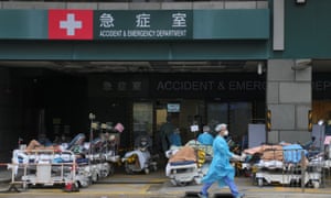 Medical staff work among patients lying in beds at a makeshift treatment area outside a hospital in Hong Kong