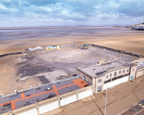 Aerial image of a building in front of a large, hollowed-out lido on the seafront
