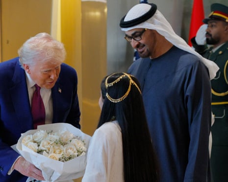 Trump receives flowers from a child upon his arrival in Abu Dhabi.