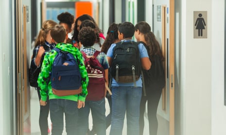 Junior school students with backpacks in a school corridor.