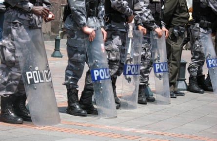 An image of police standing with riot shields placed in front of them. The word 'Policia' is visible on the first one.
