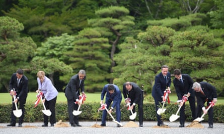 World leaders in a row each holding a spade and digging