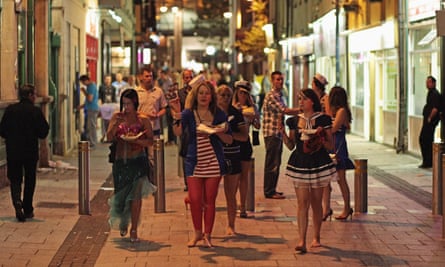People walk between pubs and clubs in Cardiff city centre.
