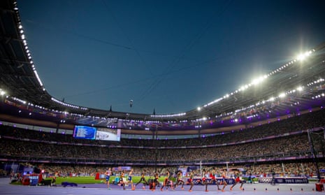 The competitors of the men’s 10000m final round a bend at Stade de France.