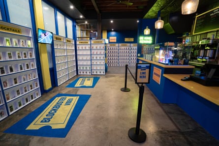 Rows of video cases on shelves, with blockbuster rugs and a blue and yellow theme