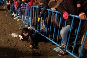 A child collects sweets from the ground during the three kings parade (Cabalgata de Reyes) in Madrid