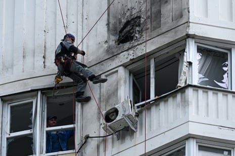 A worker inspects the damaged facade of a multi-storey apartment building after the reported drone attack in Moscow.