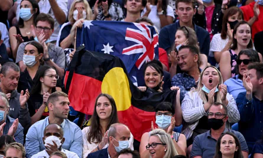 Spectators hold up the Australian and Aboriginal flags during Ash Barty's final against Danielle Collins