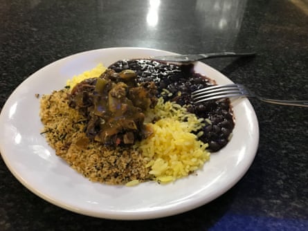 Banana skin and vegetables served with tangerine sauce, beans, rice and farinha