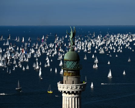 Boats sail past the lighthouse Vittoria Light at the start of the 57th Barcolana Sailing Regatta in the Gulf of Trieste on October 12, 2025.