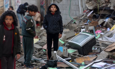 Children stand amid the rubble of a building destroyed by Israeli bombing in Rafah.