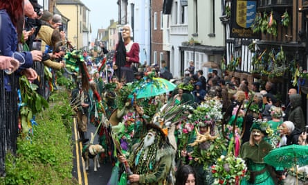Crowd of people dressed in green parading through the street in Hastings