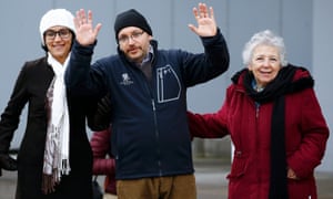 Jason Rezaian waves to media as he stands with his wife and mother after being released.