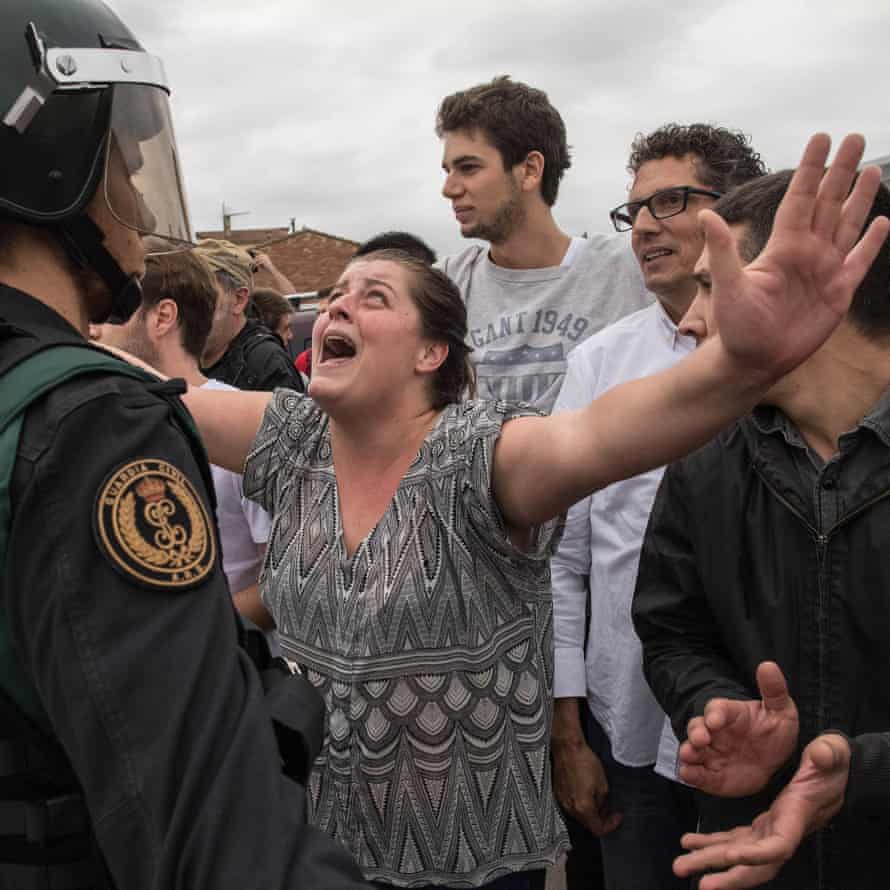 A woman protests as police move in on members of the public gathered outside to prevent them from voting in the Catalan independence referendum at a polling station in Sant Julià de Ramis