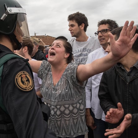 A woman protests as police move in on members of the public gathered outside to prevent them from voting in the Catalan independence referendum at a polling station in Sant Julià de Ramis