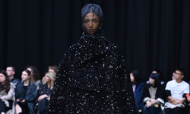 Model in sequin coat and lace veil