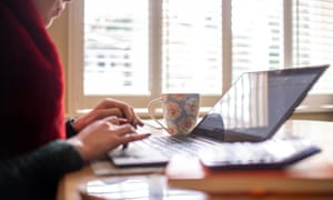 A woman using a laptop on a dining room table