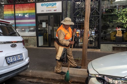A city worker sweeps the street outside the Engage men’s health clinic in Johannesburg.