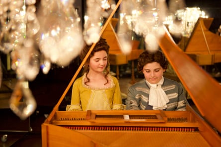 A boy and a girl in 18th century costume at a keyboard