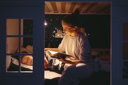 a mother reads to a child in bed