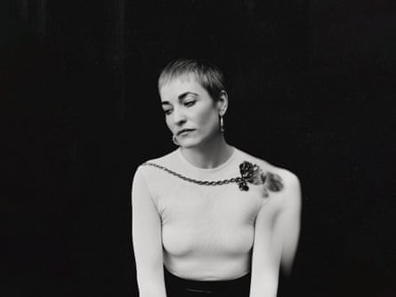 A black and white portrait of Radie Peat wearing a white top with floral detailing