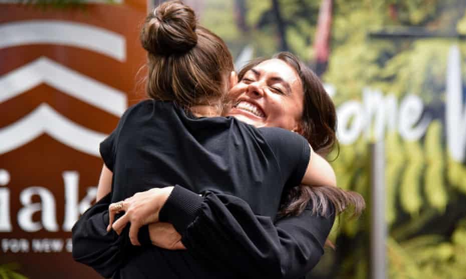 Famiglie e persone care abbracciate dopo il loro arrivo a bordo del primo volo Air New Zealand che atterra mentre inizia il viaggio senza quarantena tra l'Australia e la Nuova Zelanda